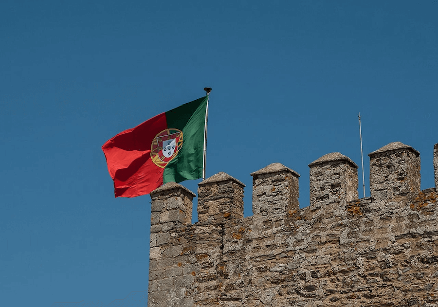 Flaga Portugalii powiewająca na blankach muru.